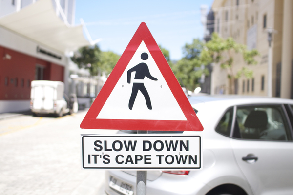 Slow Down Schild Slow Down - It's Capetown - Strassenschild in Kapstadt